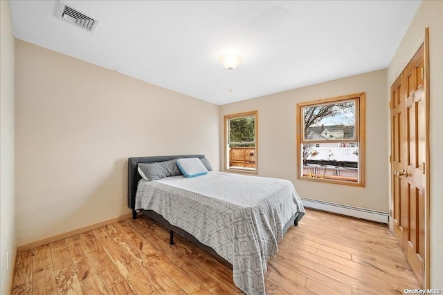 bedroom featuring light hardwood / wood-style flooring and baseboard heating