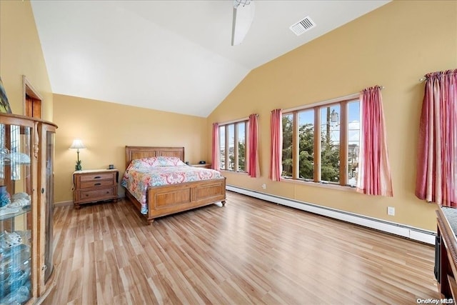 bedroom with baseboard heating, light hardwood / wood-style floors, and lofted ceiling