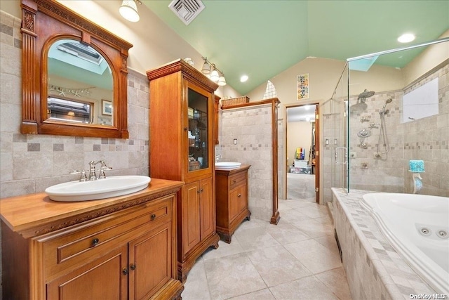 bathroom with tile patterned floors, vanity, separate shower and tub, tile walls, and lofted ceiling