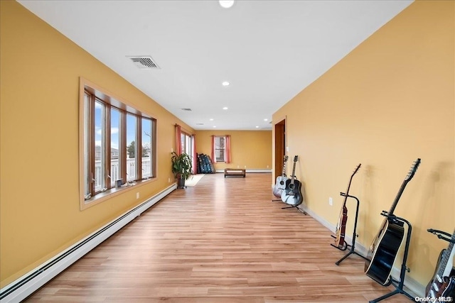 hall featuring light wood-type flooring and a baseboard heating unit