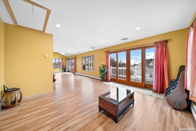 living room featuring french doors, light hardwood / wood-style floors, and a baseboard heating unit