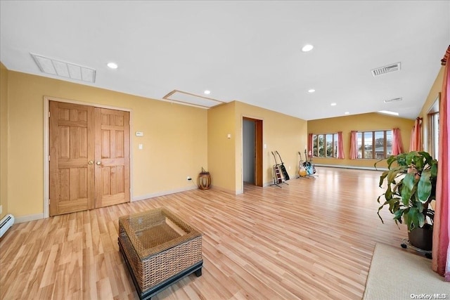 workout area with light hardwood / wood-style flooring