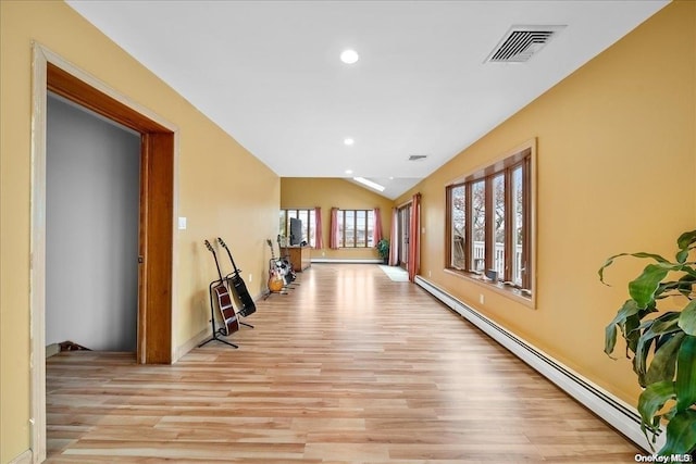 corridor with lofted ceiling, light wood-type flooring, and a baseboard radiator