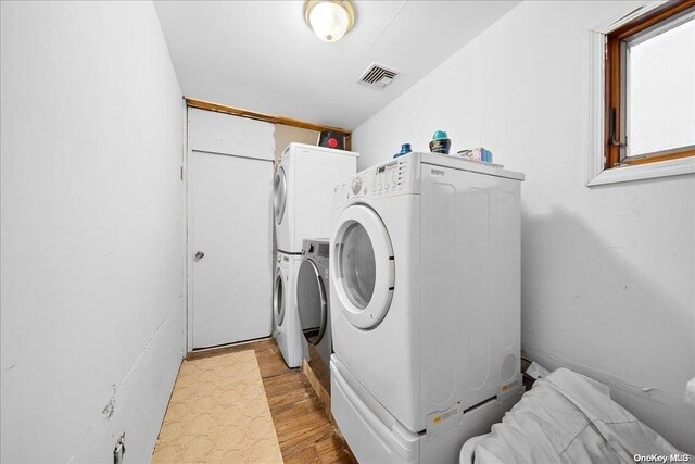 clothes washing area featuring washing machine and dryer and light wood-type flooring