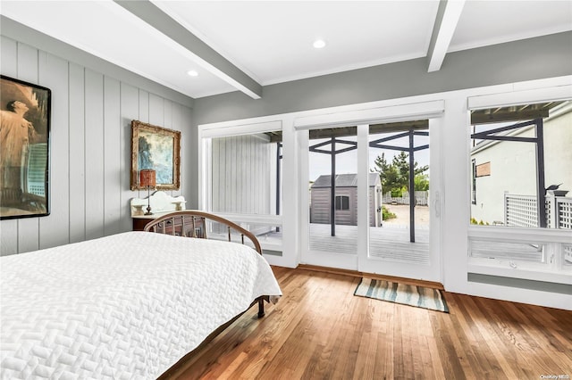 bedroom featuring access to exterior, wood-type flooring, and beamed ceiling