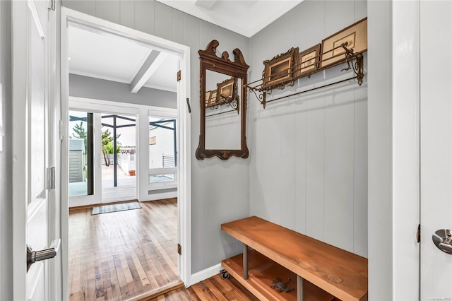 mudroom featuring hardwood / wood-style floors, wooden walls, crown molding, and beam ceiling