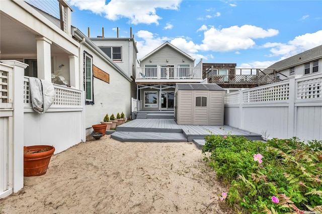 back of property with a storage shed and a wooden deck