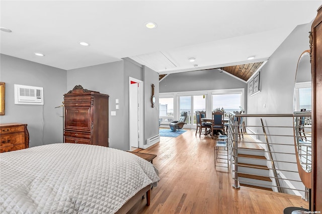 bedroom with an AC wall unit, light hardwood / wood-style floors, and lofted ceiling