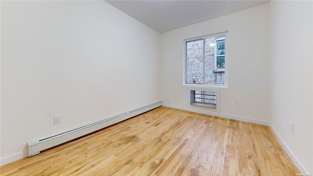 empty room with light wood-type flooring and baseboard heating