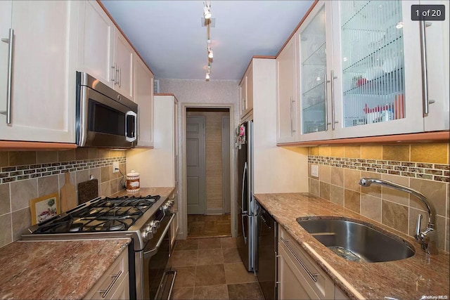 kitchen featuring sink, appliances with stainless steel finishes, tasteful backsplash, light stone counters, and white cabinetry