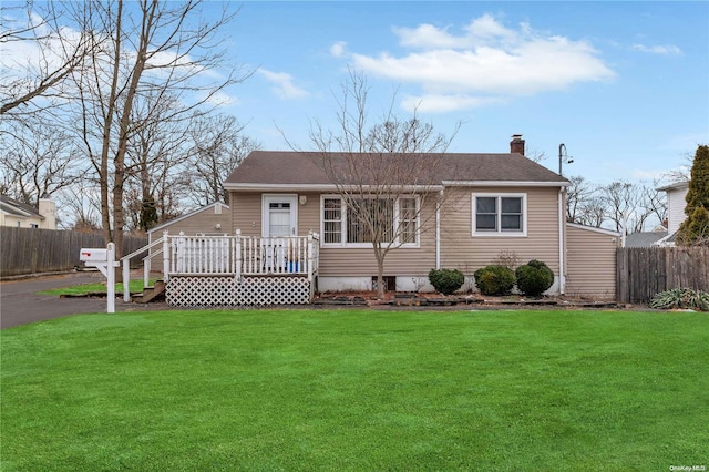 view of front of house with a wooden deck and a front lawn