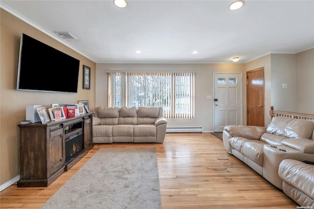 living room with ornamental molding, light hardwood / wood-style flooring, and a baseboard heating unit