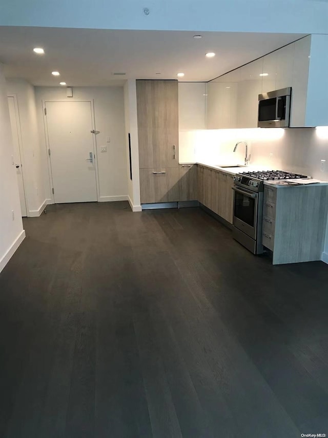 kitchen with white cabinets, sink, dark hardwood / wood-style flooring, and stainless steel appliances