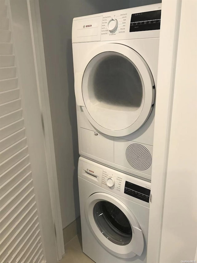 laundry area with tile patterned floors and stacked washer / dryer