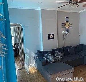 living room with crown molding, ceiling fan, and hardwood / wood-style flooring