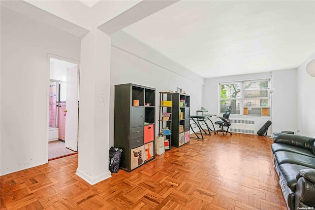 living room with radiator heating unit, light parquet flooring, and cooling unit