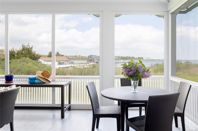 sunroom featuring a water view