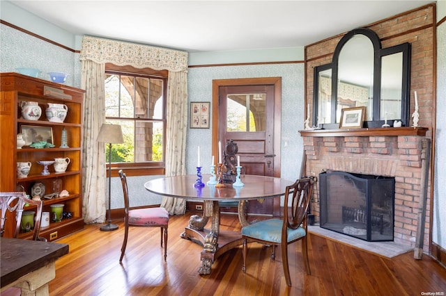 dining space featuring a fireplace and wood-type flooring