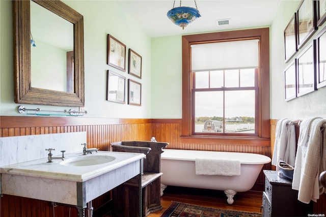 bathroom with vanity, a tub, and hardwood / wood-style flooring