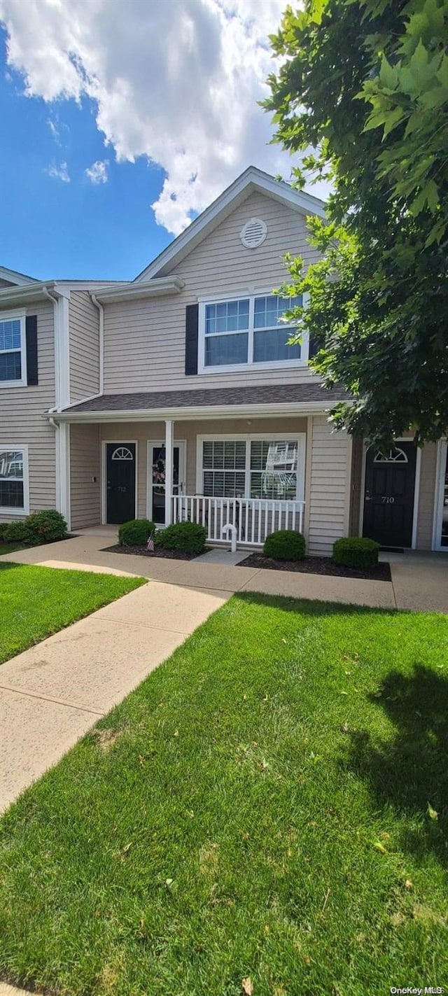 view of front of home with a porch and a front yard