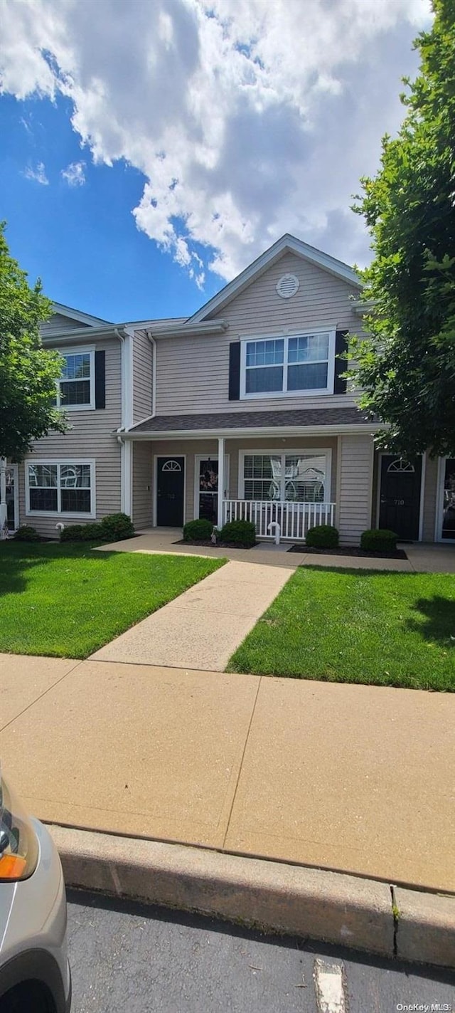 view of front of house with a porch and a front lawn