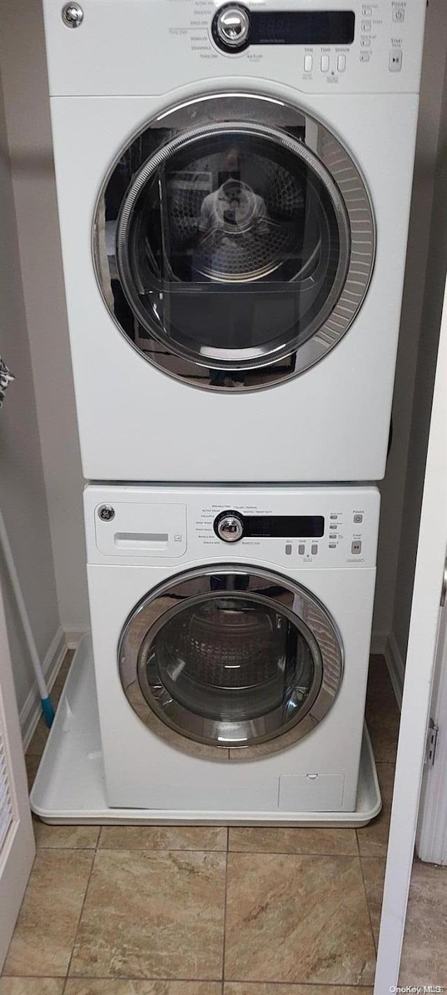 washroom featuring stacked washer / dryer and light tile patterned floors