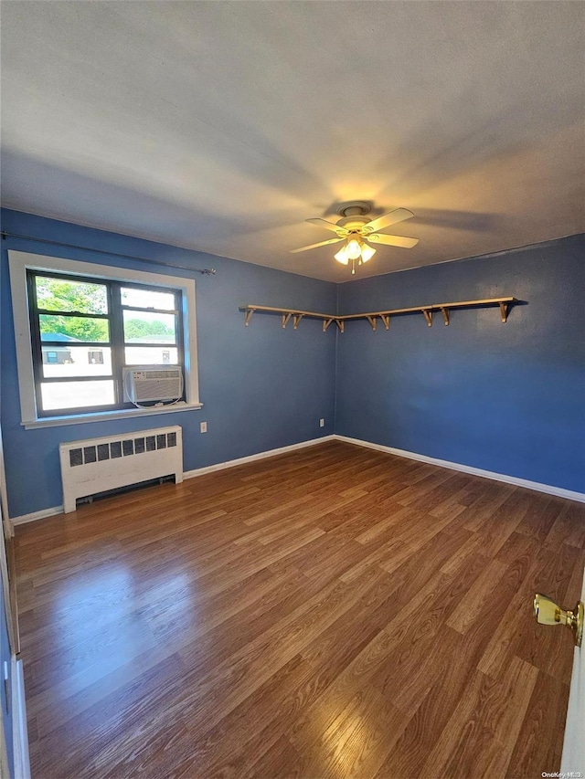 unfurnished room with ceiling fan, radiator heating unit, cooling unit, wood-type flooring, and a textured ceiling