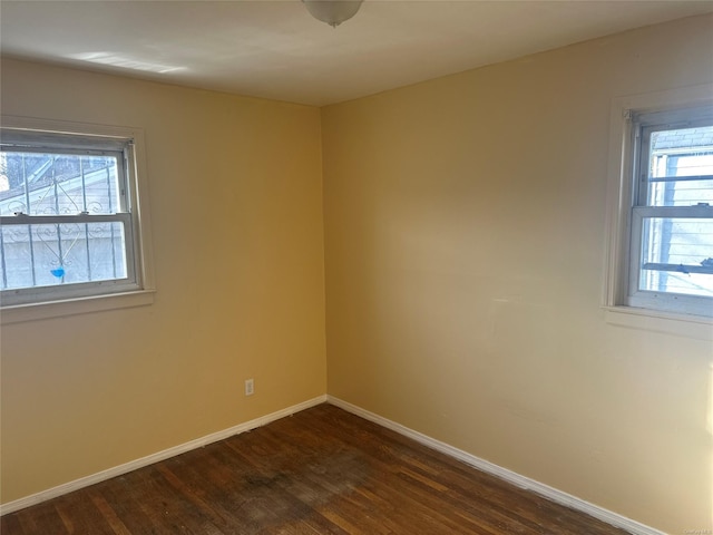 unfurnished room featuring dark hardwood / wood-style flooring and a wealth of natural light