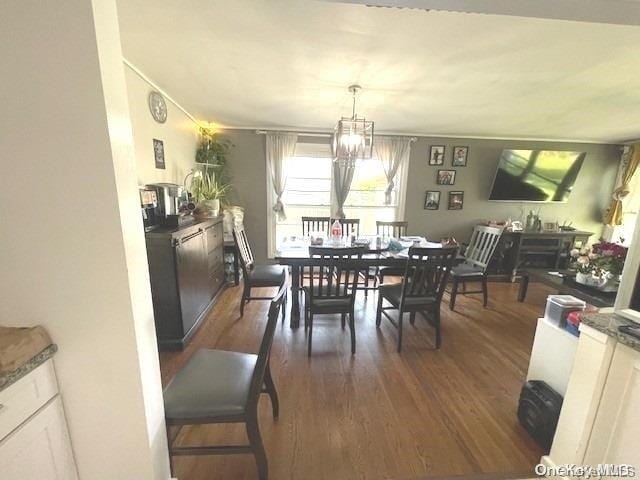 dining space featuring dark hardwood / wood-style floors and an inviting chandelier