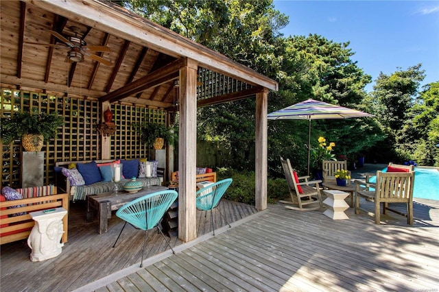 deck with an outdoor living space and ceiling fan