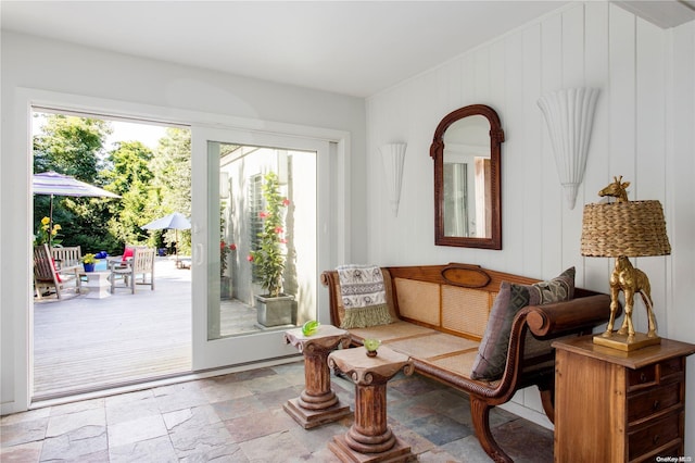 sitting room featuring plenty of natural light and wood walls