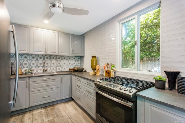 kitchen featuring gray cabinetry, stainless steel range oven, sink, and light hardwood / wood-style flooring