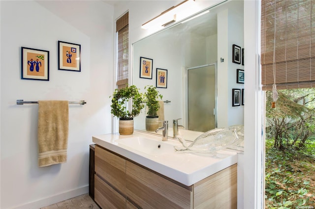 bathroom featuring tile patterned flooring, vanity, and a shower with shower door