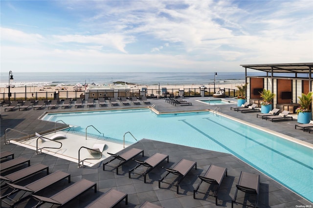 view of swimming pool featuring a water view and a patio