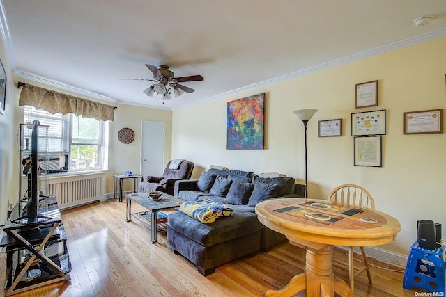 living room featuring radiator heating unit, light wood-type flooring, ceiling fan, and ornamental molding