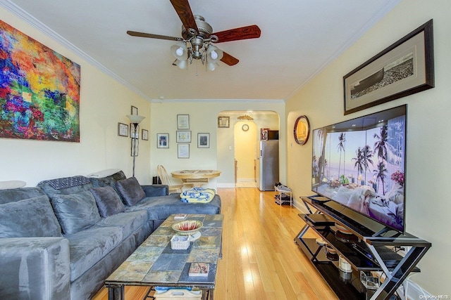 living room with wood-type flooring, ceiling fan, and crown molding