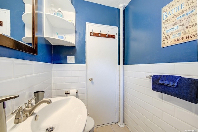 bathroom with tile patterned floors, sink, and tile walls