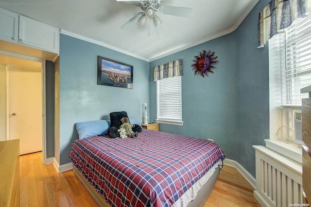 bedroom featuring radiator, ceiling fan, crown molding, and light wood-type flooring