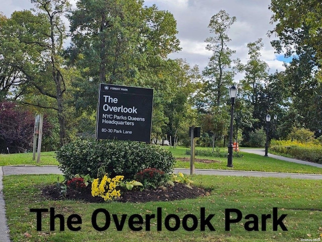 community / neighborhood sign featuring a lawn