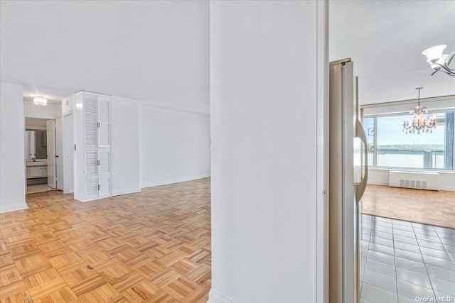 empty room featuring light parquet floors and a chandelier