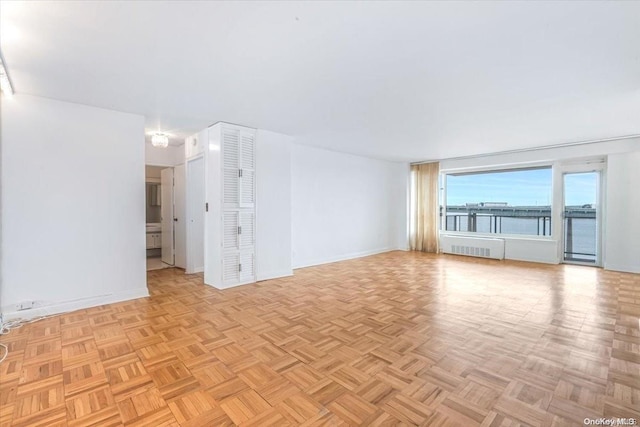 unfurnished room featuring radiator heating unit and light parquet flooring