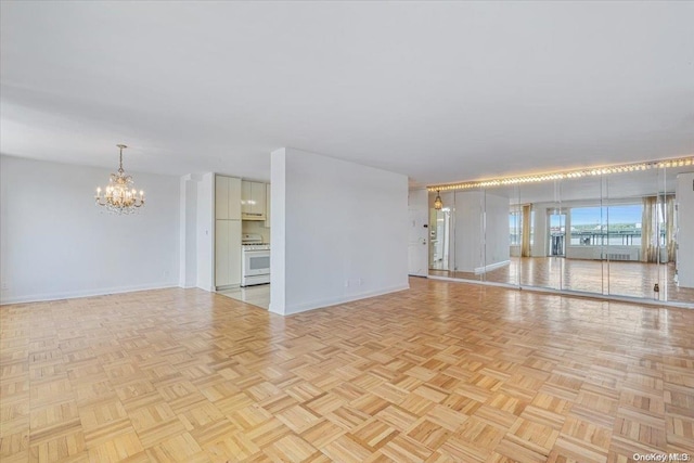 unfurnished room with light parquet flooring and a chandelier