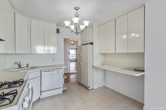 kitchen with sink, hanging light fixtures, an inviting chandelier, white appliances, and white cabinets