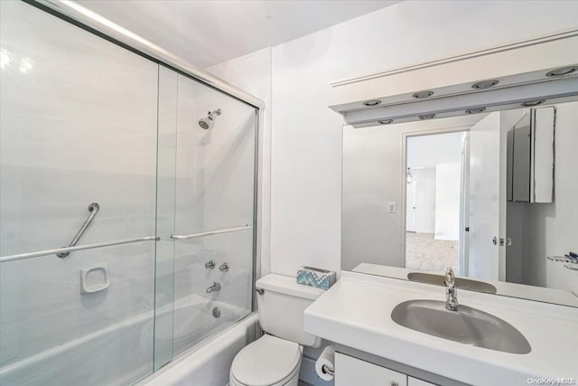 full bathroom featuring combined bath / shower with glass door, vanity, and toilet