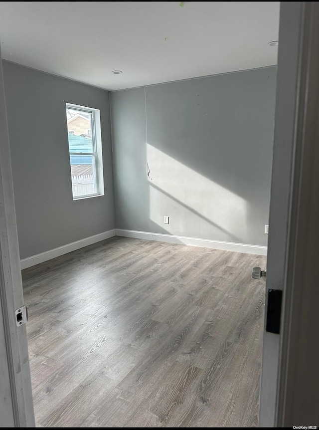 unfurnished room with wood-type flooring