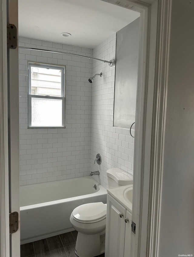 full bathroom featuring tiled shower / bath, toilet, vanity, and hardwood / wood-style flooring