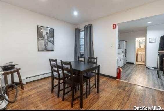 dining area featuring dark wood-type flooring and a baseboard radiator