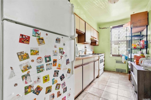 kitchen featuring white appliances, backsplash, and radiator