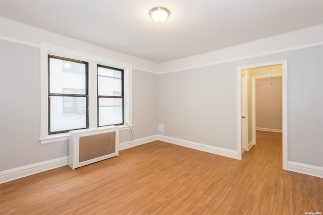 empty room with light hardwood / wood-style floors and radiator