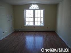 spare room with lofted ceiling and dark wood-type flooring